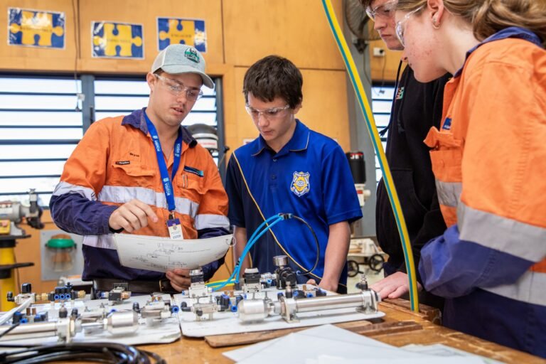 Abbot Point Operations Fourth Year Engineering (Fitting and Turning) Apprentice Bryce Doyle instructs Bowen State High School students at the QMEA's Tradie for a Day workshop.