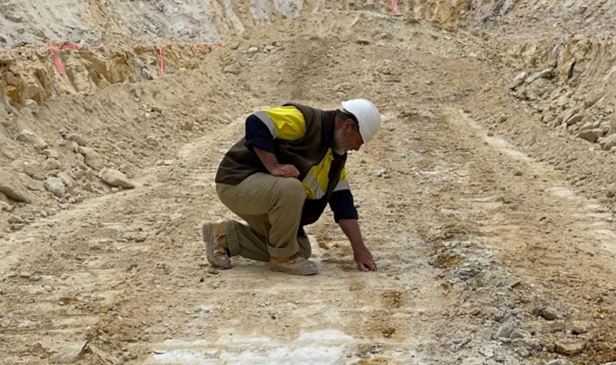 Chief executive Dean Goodwin examining bulk sample pit.