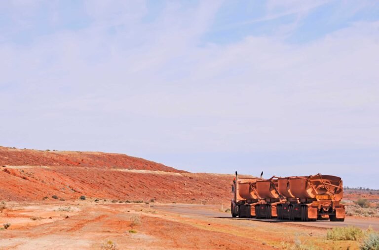 Road train towing four trailers of direct shipping ore.