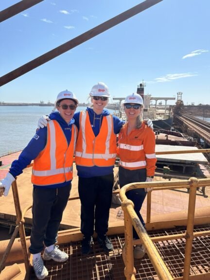 (Image source: BHP) AFLW West Coast Eagles stars Emma Swanson and Charlotte Thomas with BHP’s Stacey Turale on a ship loader at Port Hedland.